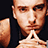 Pixelated image of a person with hands clasped near the mouth on left, pink background with blue text and symbols on right.