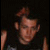 Pixelated image of a person with brown hair wearing dark clothing on left, pink pixelated text 'MMM Benji. x3' on black background right.