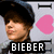 Pixelated image of a person wearing a dark cap with a pink heart and 'Bieber' text below, alongside a pink peace symbol with 'PEACE' text and a pink heart with 'LOVE' text.