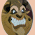 Pixelated circular icon shows a smiling brown creature with large eyes, white teeth, and dark patches on its face against a light peach background.