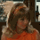 A woman with shoulder-length brown hair in an orange top appears in four showing slight head and eye movement