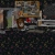 Static pixelated image of a figure in a dimly lit room with a desk, chair, and computer monitor, featuring a red object on the desk.