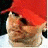 Pixelated image of a person wearing red cap and white shirt with repeated 'BOOTY' text in black-and-white striped blocks.