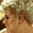 Static 48x48 pixel icon depicting a blurred figure with brown hair and light skin tones against a muted background of beige, brown, and white pixels.