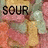 Animated sequence showing text changes over a background of colorful gummy bears, with black sans-serif text reading 'SOUR', then 'SOUR SWEET', and finally 'SOUR SWEET GONE'.