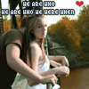 A static image of two people embracing on a bridge with autumn trees in the background, overlaid with text and a heart symbol.