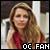 Static pixelated image of a person with long hair wearing a red top, positioned against an indistinct background with text at the bottom.