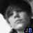 Pixelated grayscale portrait of a person with dark hair and a light-colored shirt, featuring blue text "JB" in the bottom-right corner.