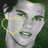 A grayscale portrait of a person with dark hair and a yellow heart outline over the left eye, set against a dark green background.