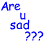Pixelated text and symbols in multiple colors on a white background, including blue 'Are u sad ???', pink 'OK', orange 'let's put a...', black 'Band Aid' with red cross, green 'on it!!!!'