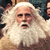 Static pixelated image of a person with long white hair and beard, wearing a light-colored robe, mouth open in a shout or yell.