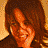 Animated contact sheet of three frames showing a woman with long brown hair smiling in warm-toned settings, displayed on a gray background.