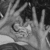 Black-and-white animated icon shows a hand with fingers extended, palm facing forward, holding a small circular object in the center of the frame.