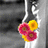 Pixelated static image shows three stylized flowers with yellow and pink petals against a gray background featuring vertical white lines.