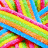 A vibrant, pixelated pattern of interwoven rainbow-colored stripes in pink, yellow, green, orange, and blue forming a dense geometric design.