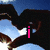 Pixelated image with four quadrants: top-left shows dark shapes against blue sky, top-right has green text on colorful background, bottom-left features a person wearing headwear and blue text, bottom-right is solid gray.
