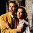 A static image with a bright pink background, featuring two people in vintage clothing and white pixelated text reading "Tonight. Tonight. It all began tonight... I saw you. And the world went away.".