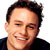 Static pixelated portrait of a smiling person with short dark hair against white background, cropped to show upper shoulders and head in close-up frame.