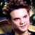 Pixelated static image of a person's face with dark hair and light skin, cropped closely to show forehead to chin against a blurred background.