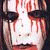 Pixelated static image of a stylized face with red and white tones, dark hair or headpiece elements on the sides, and visible pixelation artifacts across the entire frame.