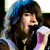 A split-screen image shows a person singing into a microphone on the left and pink hearts with blue text on the right.