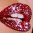 Pixelated close-up of lips with glossy red and pink tones, showing teeth and a slightly open mouth against a light brown background.