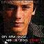 Pixelated static image of a person's face with partial text elements and color artifacts on black background.