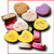 Pixelated cluster of colorful circular shapes resembling stylized flowers or candies with varied pastel and bright hues, set against a white background.