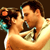 Static pixelated image of two people kissing with visible facial features and partial clothing details on a dark background.