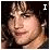 A pixelated image of a person with dark hair and light skin, featuring text elements in different positions across three