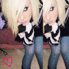 A static image shows a person with long blonde hair wearing a black and white striped top and blue jeans, with a pink heart symbol in the bottom left corner.