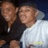 Two pixelated figures in close proximity, one wearing dark clothing and the other light-colored shirt with a small green detail.