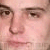 Pixelated close-up of a human face showing eyes, nose, and mouth with brown eyebrows and light skin tones.