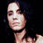 A static image shows a person with long dark hair, two side-by-side portraits of the same individual in different lighting conditions, and an 'Anarchy' symbol below text reading Criss Angel.