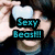 Pixelated image of a person holding a light blue object with text overlay reading "Sexy Beast!!" in cyan block letters.