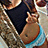 Pixelated image of a person in dark clothing holding an object with blue and brown tones against a textured background.