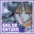 Pixelated image of a character with light skin and dark hair, featuring text "SAILOR SATURN" in white block letters on a purple rectangle at the bottom left.