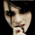 Pixelated close-up of a person's face with dark hair and visible facial features against a black background.