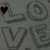A static image of repeated 'LOVE' text in gray 3D letters with black heart symbols appearing at different positions across the