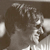Pixelated grayscale image of a figure with light-colored hair and a dark top, partially obscured by low resolution and pixelation.