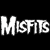 A black-and-white pixelated image featuring the word "MISFITS" in bold, blocky letters on the left and a stylized skull with large eyes and a wide grin on the right.