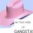 A pink cowboy hat with a dark band appears against a light blue background, partially obscuring text below.