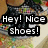 A pixelated image of a person's lower legs and feet wearing black sneakers with white soles, standing on a patterned surface.