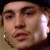 Pixelated close-up of a person's face with visible eyes, nose, mouth, and ear, showing partial facial features and earlobe.