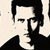 Pixelated black-and-white static icon of a stylized human face with dark hair and clothing, featuring high-contrast shading on the forehead, nose, and jawline against a light background.
