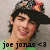 Pixelated image of a person with dark hair wearing a hat, smiling, with text 'joe jonas <3' at the bottom.