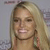 Pixelated close-up of a person with long blonde hair, light skin, and a smiling expression against a muted background.