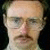 A pixelated image of a person with glasses and a mustache, alongside two figures in blue and orange clothing holding an object.