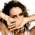Pixelated image of a person with dark brown hair wearing a dark sleeveless top, arms raised in a flexing pose against a white background.