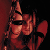 Animated sequence showing a person with dark hair and black straps in red-toned lighting, transitioning from close-up to wider view.